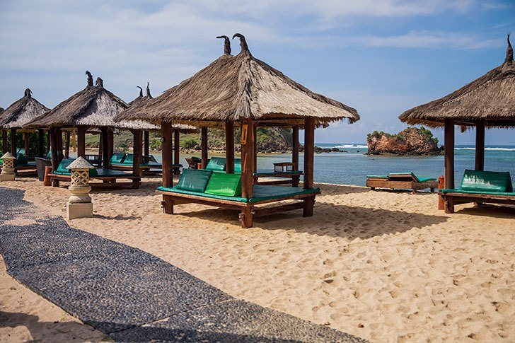 Beautiful beach scene in Indonesia with umbrellas and beach chairs